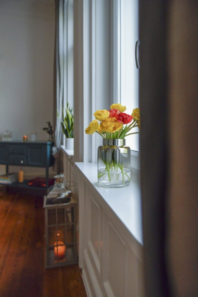 Fensternische mit Blumen und Kerze