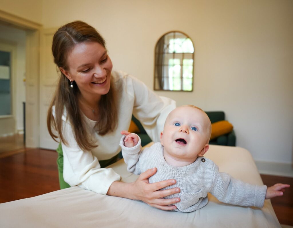 Osteopathin mit einem Säugling auf der Behandlungsliege