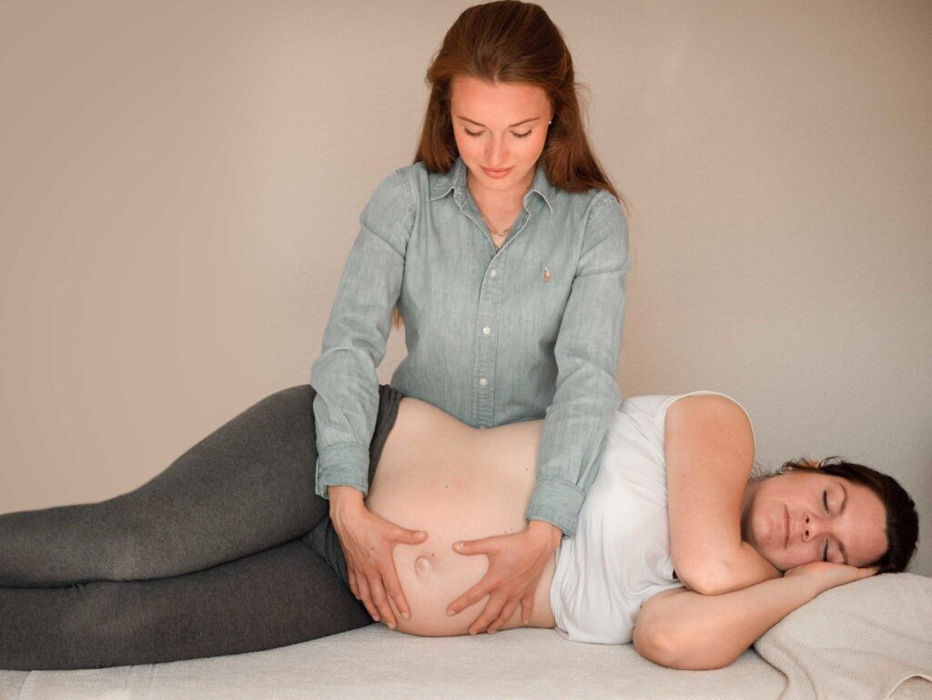 Osteopathische Behandlung einer Schwangeren in Seitenlage