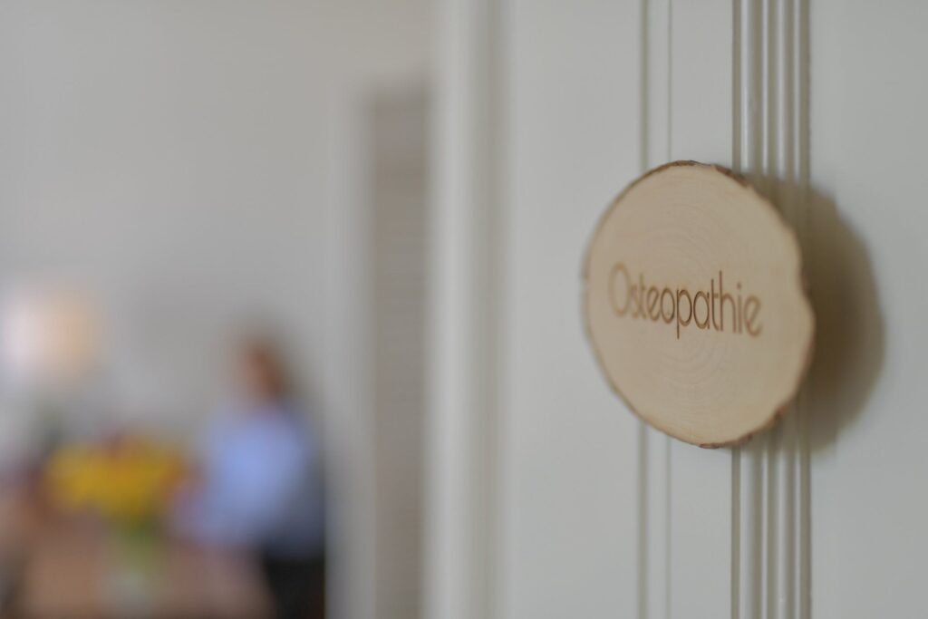Holzschild mit dem Logo der Praxis